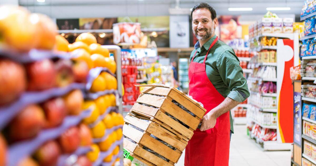 retail merchandiser pushing crates of food in store